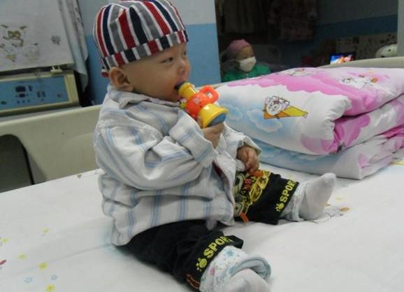 孩子刚刚输完了药,结束了一天的治疗,高兴的玩耍着