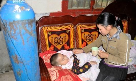 妈妈在给已经失明的小成朋喂药