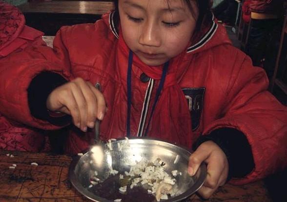每个孩子只有两个丸子，瞧这小姑娘都不舍得吃，一粒丸子咬一口才吃最后一口饭