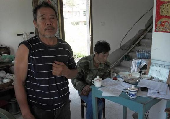 张贤生讲诉自己的家里情况,乡村领导站在他家里。