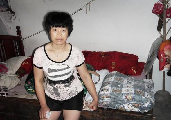 潘爱君坐在自己的床上,生活条件困难。