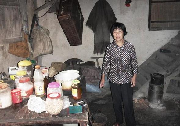 盛美芳站在家里,没有像样的生活用品,家里生活困难,家里靠她一个人生活。