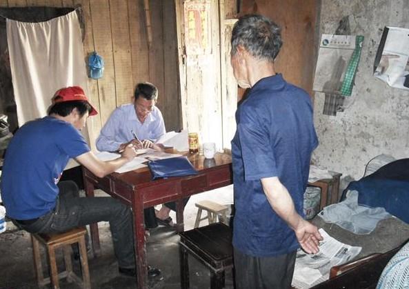 施乐会志愿者和乡村领导在受助人叶天金家里了解情况,老人站在旁边讲诉。