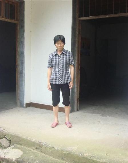 谢美仙站在大门口欢迎自愿者的到来