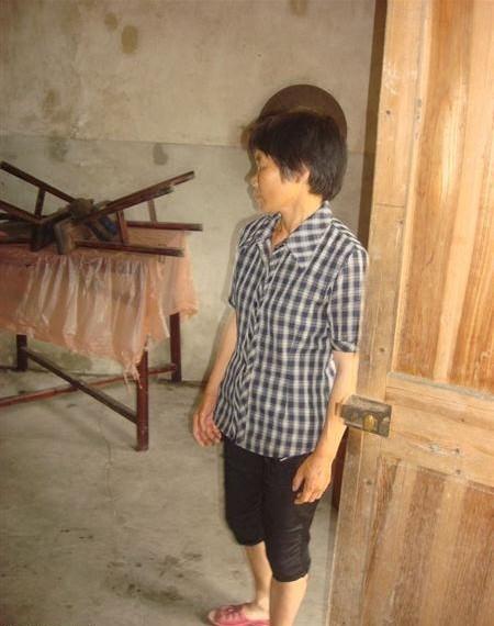 谢美仙站在屋里正跟社工诉说家里的情况