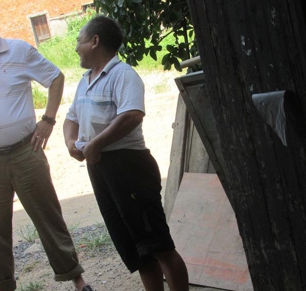 王培海提着裤腰带和志愿者讲诉自己身体情况,样子很憨厚