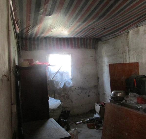 王培海家里很脏乱,墙壁上的白石灰都变黑了,地上倒满了杂物