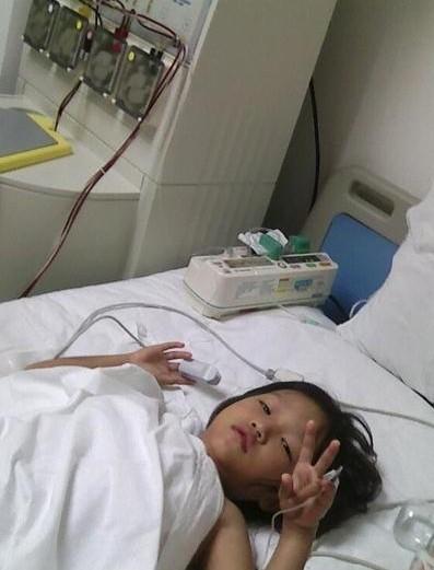 小娟娟在医院治疗的时候，强忍疼痛，对妈妈做了一个胜利的手势