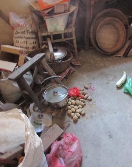 受助人陈菊兰家里堆满了乱七八糟的东西,地上的土豆放了很久很干瘪