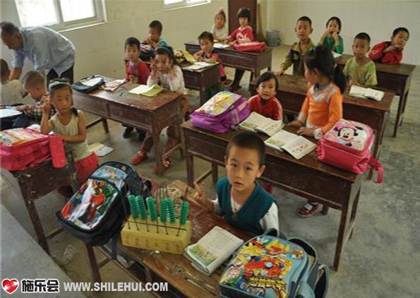 志愿者在了解孩子们的学习情况,孩子们都抢着说,要喝干净水。