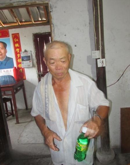 天气炎热朱文奎拿出饮料给志愿者,说这还是邻里送的