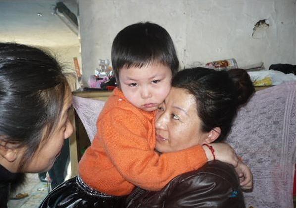 妈妈抱着米家宁,很爱怜女儿,但她现在实在没有钱给女儿继续治疗白血病
