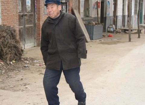 老人腿疼得厉害,走路一颠一颠的。