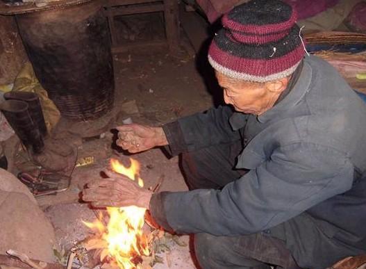 山里温度太低了,又下着小雪,廉正常老人进屋连忙烤火取暖。