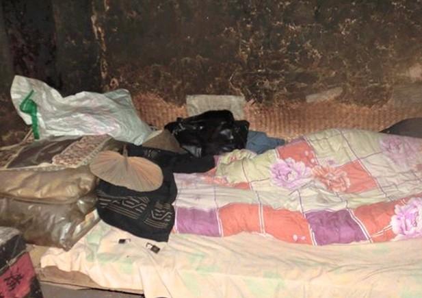 老人睡觉的床,床上仅铺着一条薄薄的褥子下面还露着夏天的席子