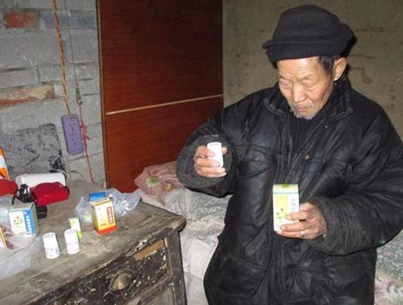 李宗锋老人拿着要服用的药