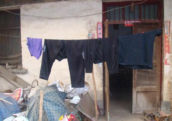 李振合老人没有像样的衣服,院内到处都是废品。