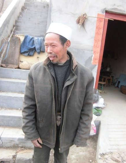 孤寡无依的老人站在自家门口看着我们一行人的到来。