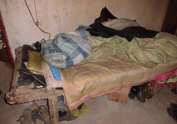 老人破烂不堪的床铺,薄薄的褥子冬天老人也不知道是怎么过来的。