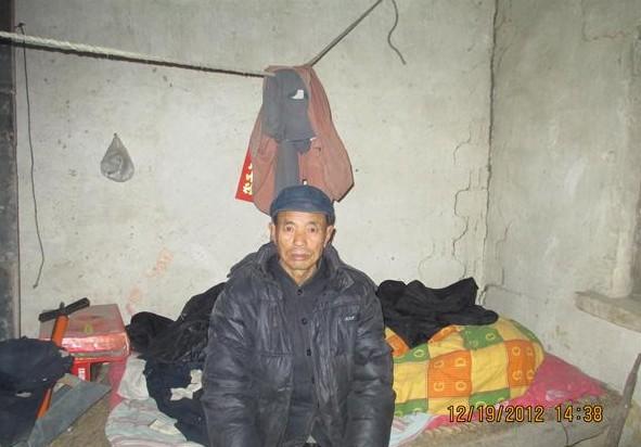 在寒冷的冬天里,老人用砖头支起的床,上面铺着很薄的垫子,仅一条棉被。