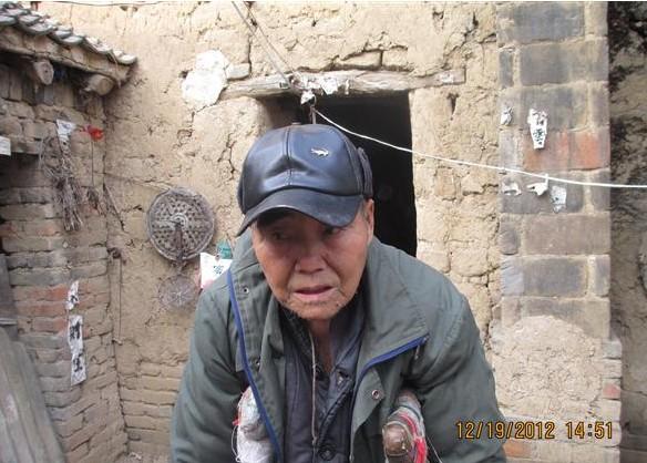 张国俊老人不能站立,要靠着双拐。