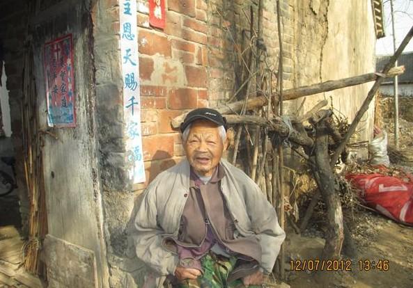 李文兴老人坐在外边晒太阳,虽然是中午了,天气还是很冷,但老人穿的那么少,还没有棉衣。
