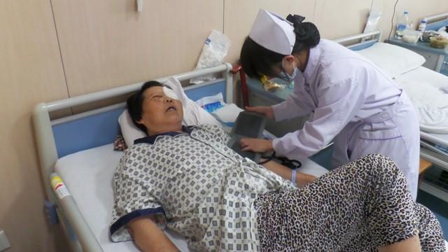 护士为做完白内障手术的老人进行身体检查,老人状况良好。