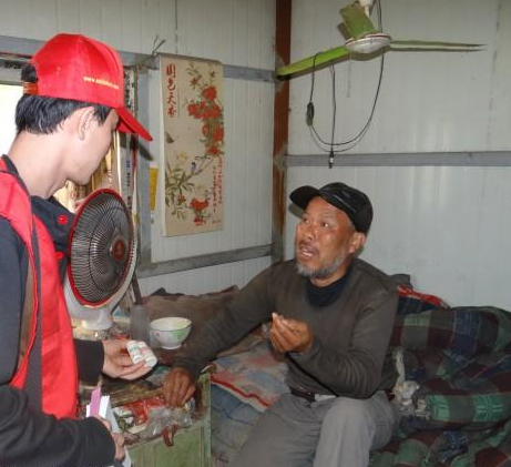 社工在向受助人了解病情,因为受助人患有遗传性病,半身不遂离不开药。