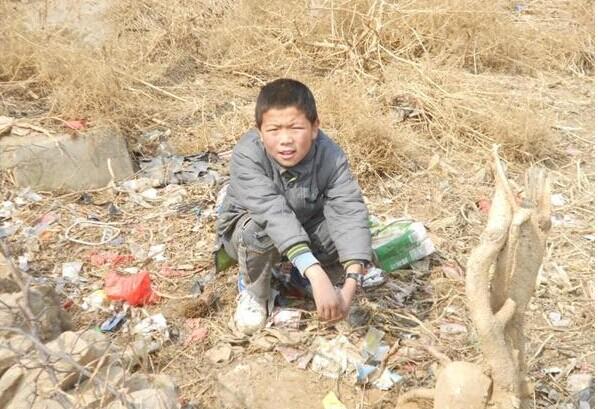 受助人冯文仓在家门口的荒地上,平时他在这里捡些别人扔掉的废品