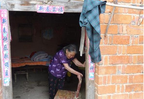 吴秀连老人依靠一把椅子,艰难的移动到门口坐下透秀气