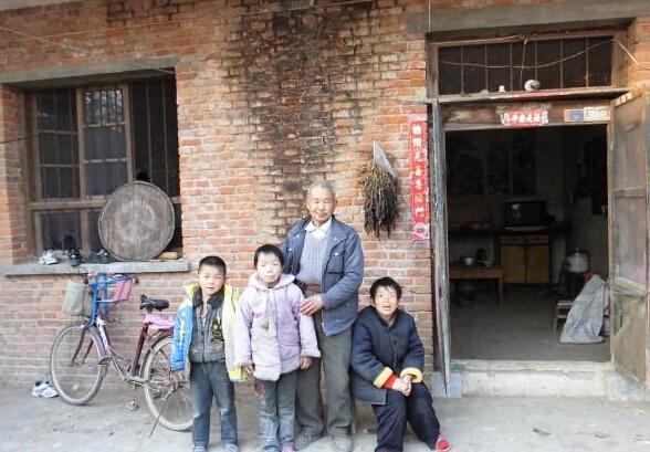 王荣歌和年近60的父亲、呆傻的母亲、年幼的弟弟一家四口人的合影照