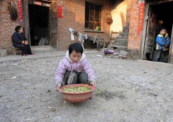 王荣歌是个勤劳懂事的孩子,正在帮助大人给家里养的鸡子拌食