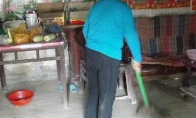 老人在收拾屋子迎接社工的到来