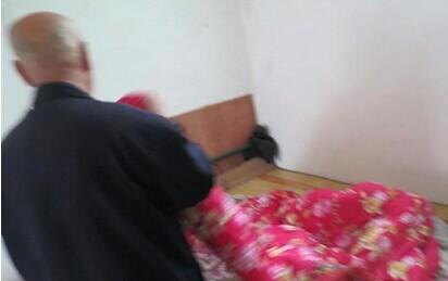 王长安老人在整理床铺