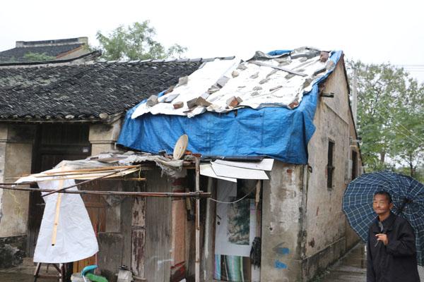 老人站在唯一可以遮风挡雨的家门口,无助的眼神在向我们求助