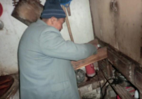 钟金福在整理自己的东西,家里的家具显得很破旧。