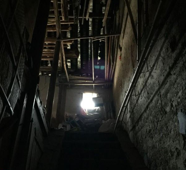 曹燕家中很是破旧,土墙和破旧的木制楼梯。