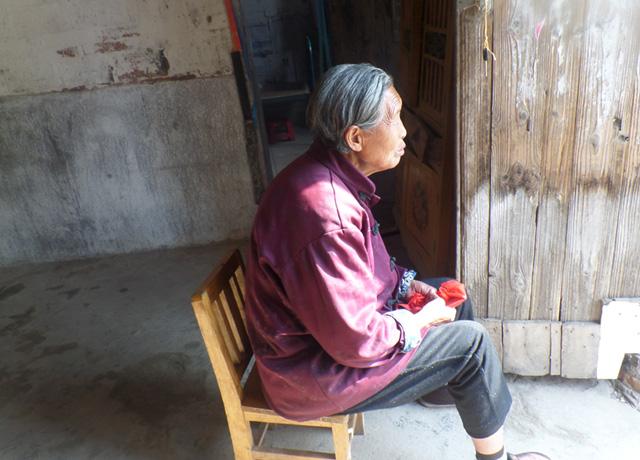 老人无助的坐在家门口,期盼好心人的帮助