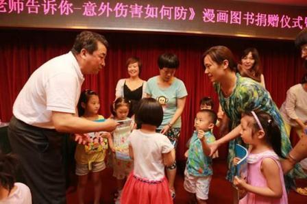 姜昆老师在给孩子们赠书。