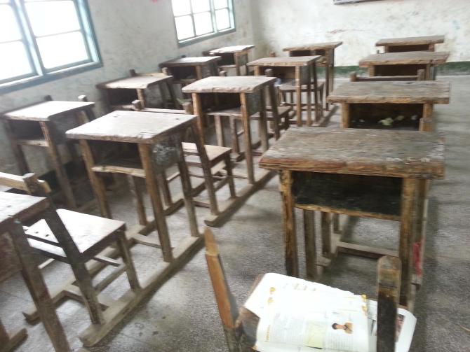 许多桌面已经凹凸不平、发白发霉,然而却摆放得很整齐。